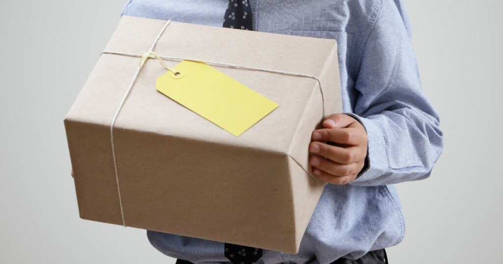 Boy with gift or delivery guy with brown wrapped package